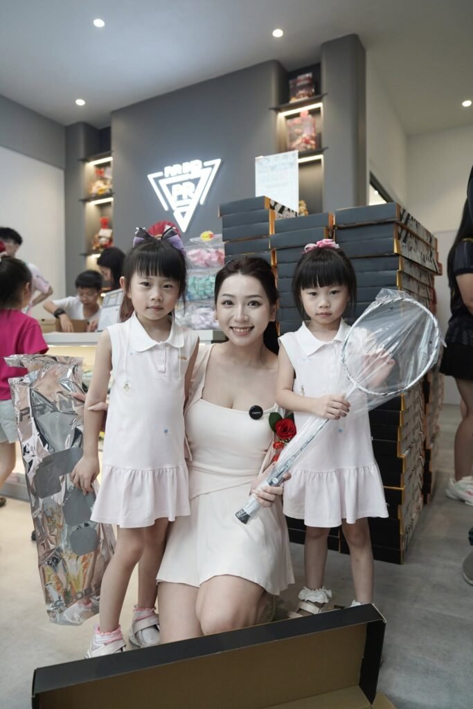 A mother and two children holding a racket inside the PRIND Austin JB store
